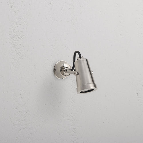 Cambridge Wall Spotlight 24V in polished nickel with adjustable head, mounted on a white outdoor wall.